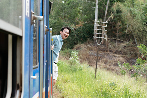 A happy traveler leaning out of a train door, embracing the fresh air and scenic beauty of tea fields. The image conveys the joy of slow travel, cultural immersion, and breathtaking landscapes, perfect for promoting tourism, eco-travel, and destination experiences.