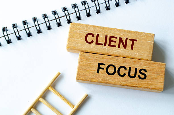 istock Client focus text written on a spiral notepad placed beside wooden blocks and ladder illustrating customer prioritization. 2236915468