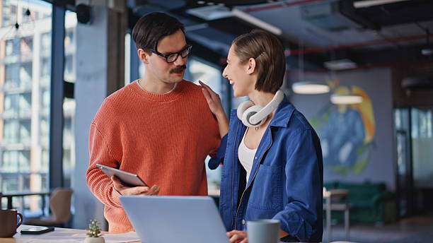 istock Corporate employees discussing tablet data standing at office. Two colleagues 2236917211