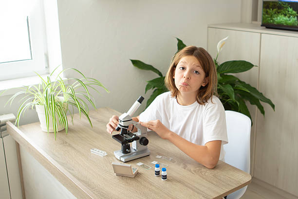 istock Girl studies biology at home while observing plants through a microscope, preparing for her return to school and online education 2236922159