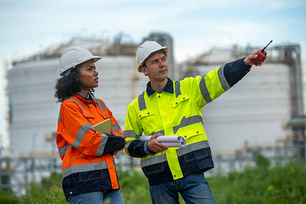 istock Engineers wear safety gear inspecting or document related to plants environment features large industrial chimneys related energy industrial work and environmental monitor carbon credit concept. 2236924638
