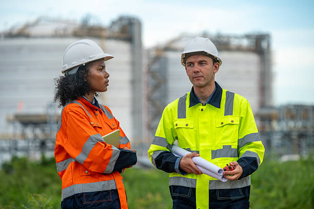 istock Engineers wear safety gear inspecting or document related to plants environment features large industrial chimneys related energy industrial work and environmental monitor carbon credit concept. 2236924642
