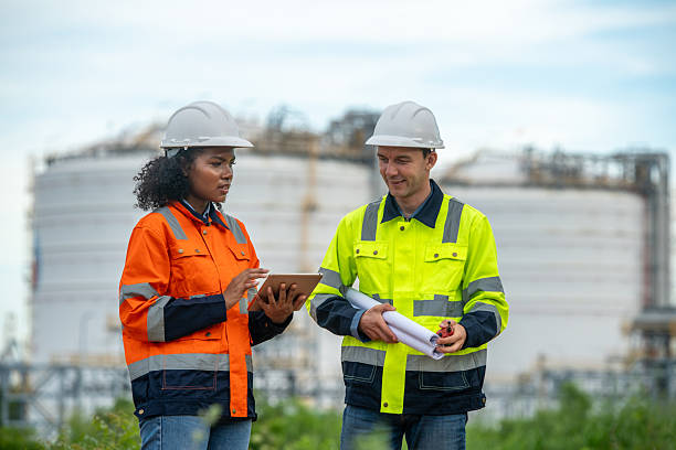 istock Engineers wear safety gear inspecting or document related to plants environment features large industrial chimneys related energy industrial work and environmental monitor carbon credit concept. 2236924649