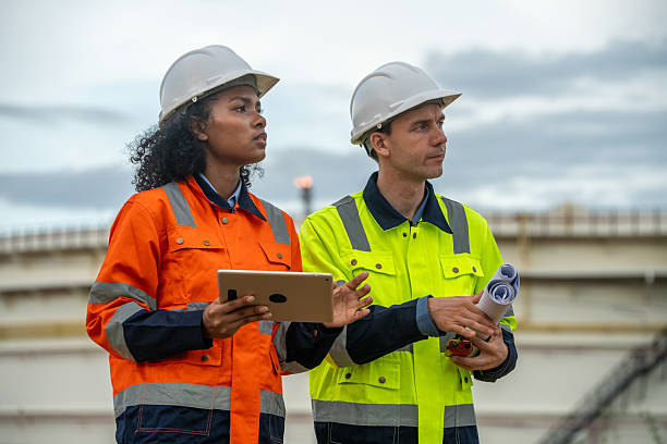 istock Engineers wear safety gear inspecting or document related to plants environment features large industrial chimneys related energy industrial work and environmental monitor carbon credit concept. 2236924654