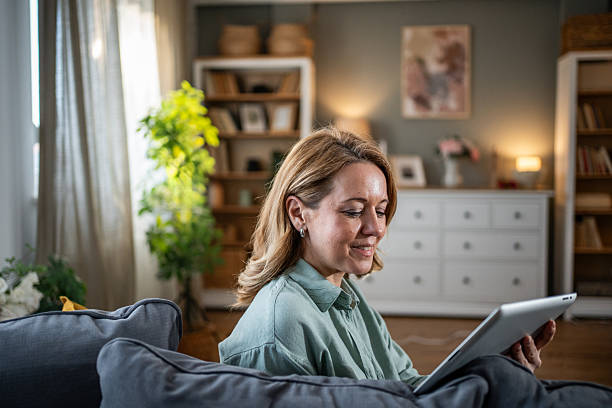 istock Mature adult woman relaxing on sofa using digital tablet 2236926746