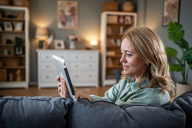istock Woman relaxing at home, browsing internet on tablet 2236926820