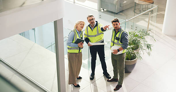 istock Planning, architect and group with blueprint in office, talking or teamwork for property development. Civil engineer, woman and men with document for architecture, above and discussion for renovation 2236931378