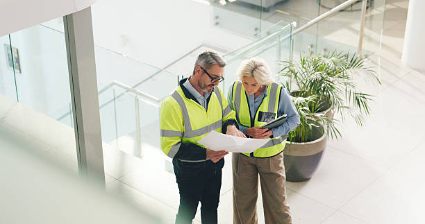 istock Real estate, architect and people with blueprint in office, property development or team with ideas. Civil engineer, woman and man with document for architecture, above and discussion for renovation 2236931458