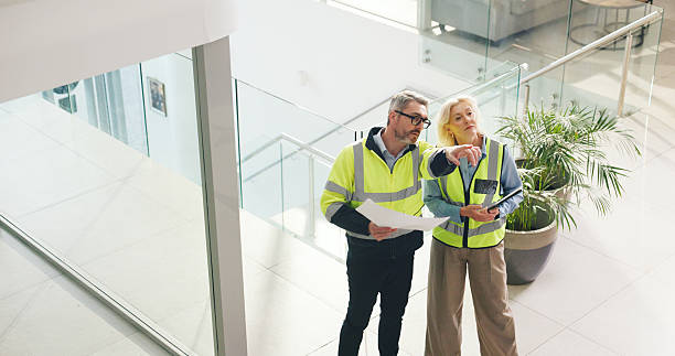 istock Architect, pointing and people with blueprint in office, talk and planning for property development. Civil engineer, mature woman and man with document for architecture, above and chat for renovation 2236931481