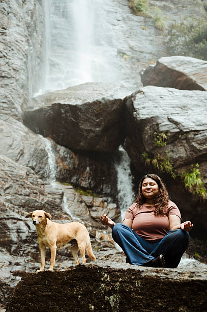 istock Traveler Meditating Outdoors with Dog by Scenic Waterfall 2236931954