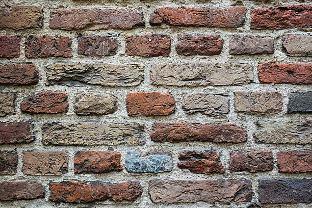 Old, weathered, colorful brick wall pattern or background. Front view, close up, no people