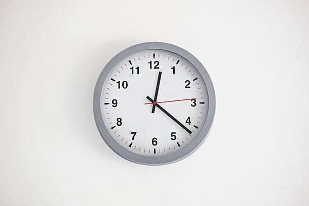 istock Modern, analog, white face large clock hanging on a white wall. Interior close up shot, no people 2236937344