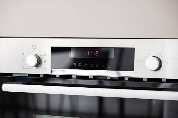 istock Modern, electric, integrated kitchen oven face with LCD and settings buttons and knobs. Close up, bright shot, natural window light, no people 2236937360