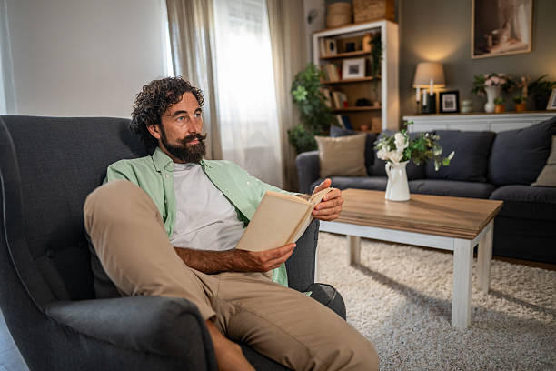 istock Man reading book relaxing in armchair at home 2236937745