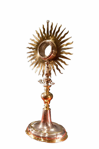 A beautifully crafted monstrance stands tall on an altar, shimmering in gold and silver. Its intricate design highlights spiritual significance and reverence in a place of worship.