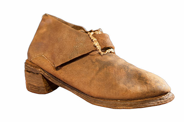 This vintage leather shoe showcases its unique design with a rounded toe and a low heel. The worn texture reflects its history, making it an interesting piece for collectors or exhibits.