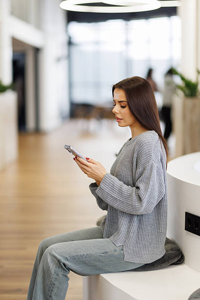 istock Small business entrepreneur looking at her phone and smiling while communicating with her office 2236941678