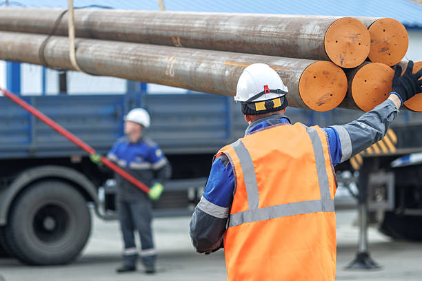 istock Construction Workers Handling Heavy Steel Pipes Outdoors 2236942751