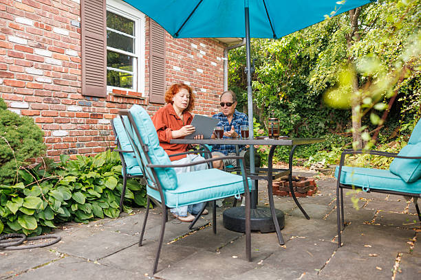 istock Advisor reviewing coverage options with visually impaired man on outdoor patio. 47-year-old consultant explaining policy details to 82-year-old client during home visit consultation. 2236943087