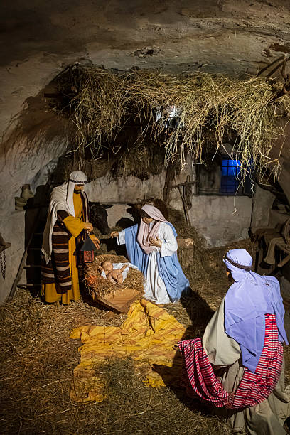 Closeup of Nativity scene with baby Jesus with Christmas lights out of focus for the true meaning of Christian Holiday