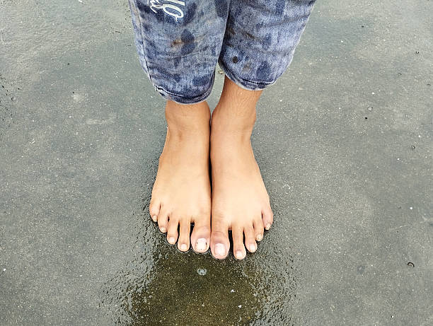 Children with bare feet touching on the sand beach