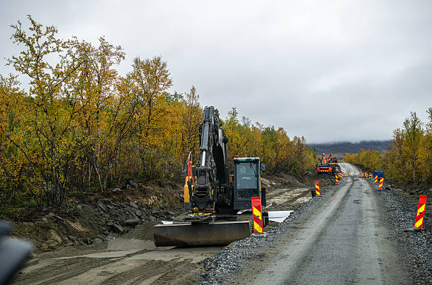 istock Excavator working on road construction site in autumn forest 2236947826