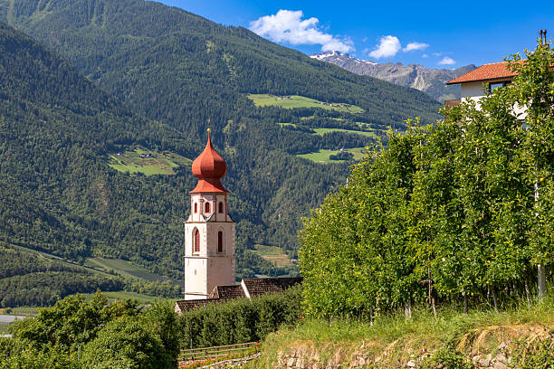 Dlijia Da Curt Catholic church at Mareo commune, Province of Bolzano, South Tyrol, Italy. Picturesque autumn landscape from Italian Dolomites mountains