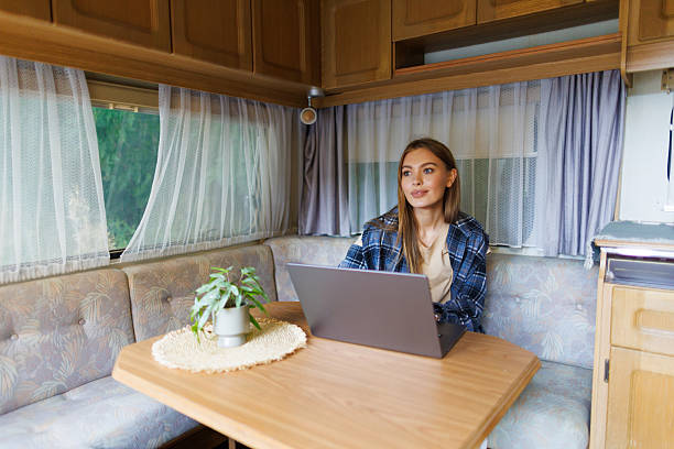 istock Young woman working on laptop while sitting at table in camper 2236954171