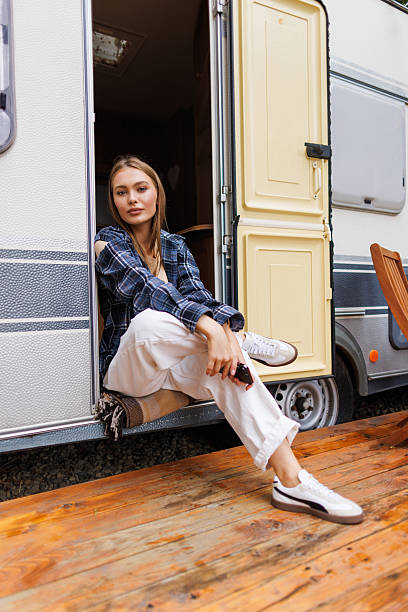 istock Young woman sitting in front of camper 2236954432