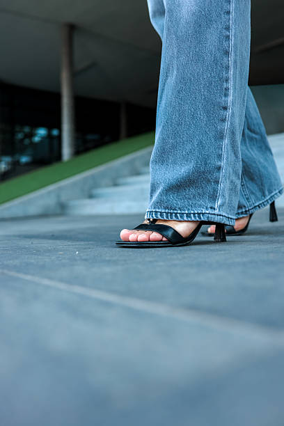 istock Woman in black heels and jeans walking on steps 2236954731