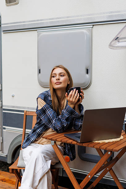 istock Young woman looking on laptop while sitting in front of camper 2236954772