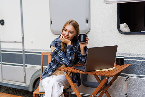 istock Young woman looking on laptop while sitting in front of camper 2236955556