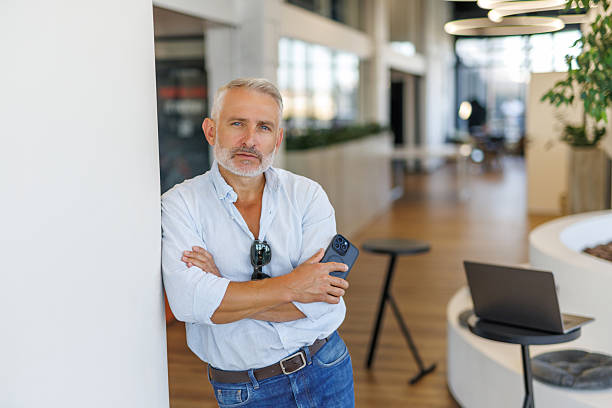 istock Middle aged businessman executive holding smartphone looking at camera standing outside office. Portrait. 2236956422