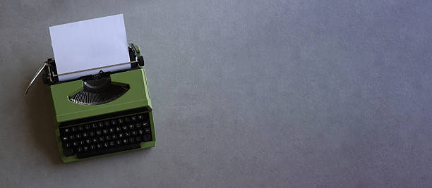 istock A vintage green typewriter on a gray background with blank paper and ample copy space. 2236957112