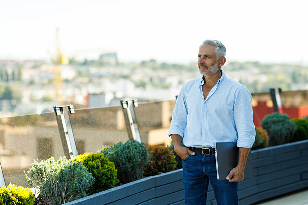 istock mature businessman working on laptop at rooftop 2236957591