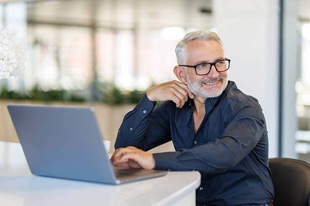 istock Mature male entrepreneur or executive sitting at work desk using laptop computer technology. 2236957627