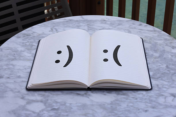 Open notebook or two distinct paper surfaces. The left page (or surface) is lighter, with a clear happy emoticon face (\