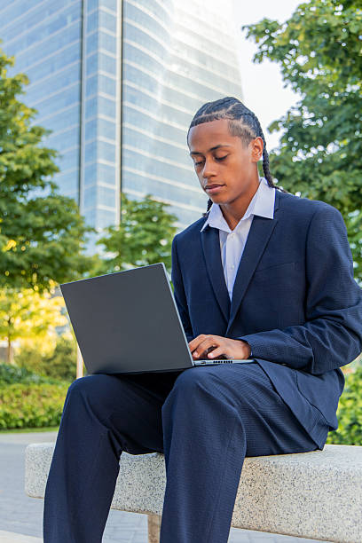 istock Young businessman working outdoors on laptop in financial district 2236960094