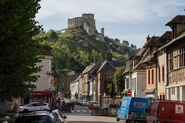 Les Andelys, France - August 28, 2025: The village of Les Andelys in France with beautifull old architecture with houses and the church. The medieval castle ruins of Chateau Gaillard are visible on the hill.