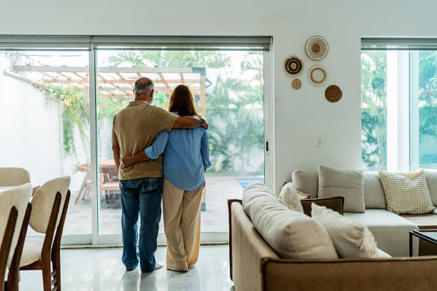 istock Senior couple looking through window at home 2236962681