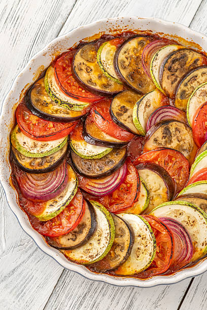 Round baking pot filled with circularly arranged baked vegetable ratatouille