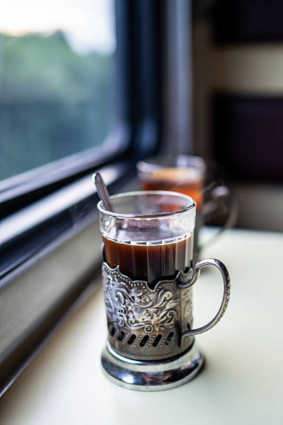 istock Close up tea glass holder with spoon on train table by window. Travel drink onboard classic service 2236979207