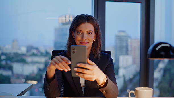istock Relaxed executive scrolling cellphone at evening office closeup. Smiling woman 2236981264