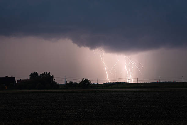 istock Dramatic lightning storm at night with silhouetted trees and fence. 2236981946