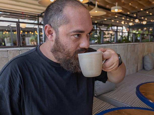 istock Young man enjoying coffee at a cafe 2236982364
