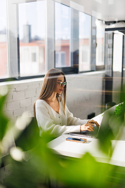 istock Image of young beautiful woman smiling while working with laptop in office 2236982980