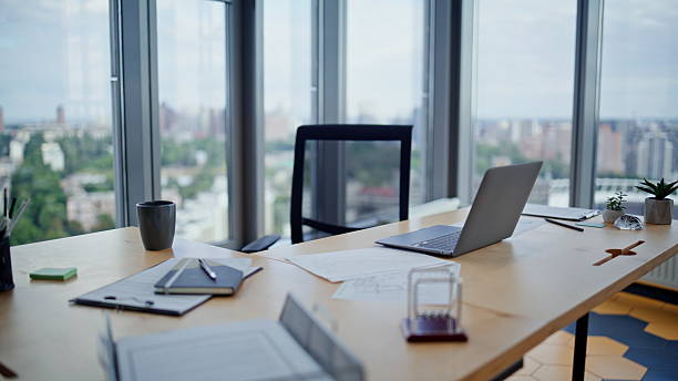 istock Empty corporate workspace laptop in office with city view. Workplace interior 2236986653