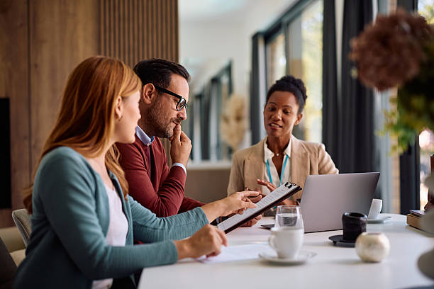 istock Smiling couple analyzing the contract during a meeting with real estate agent. 2236990183