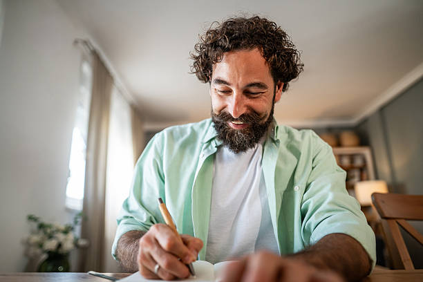 istock Happy man writing in journal, finding inspiration at home 2236993921