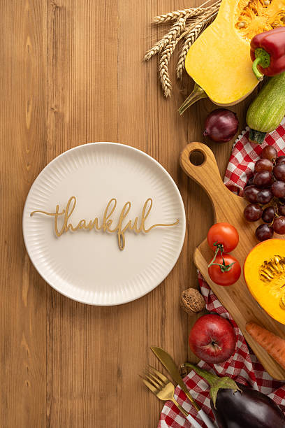 istock Vertical view of a Thanksgiving scene featuring a thankful plate surrounded by vegetables and fruits 2236996073